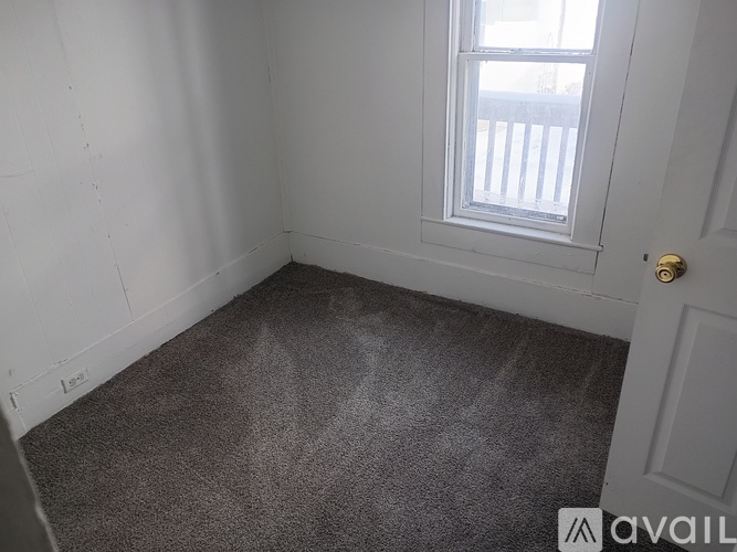 A room with a carpeted floor and a window.