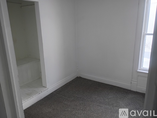 A room with a carpeted floor and a window.