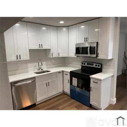 A kitchen with white cabinets and a stainless steel dishwasher.