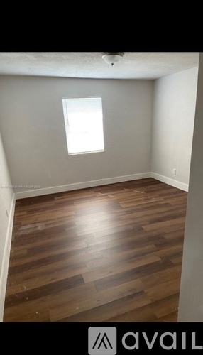A room with wooden flooring and a window.