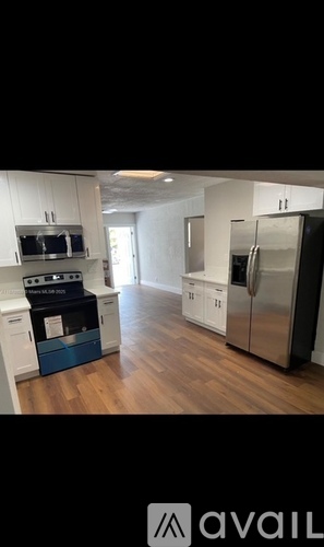 A kitchen with a stove top oven and a refrigerator.