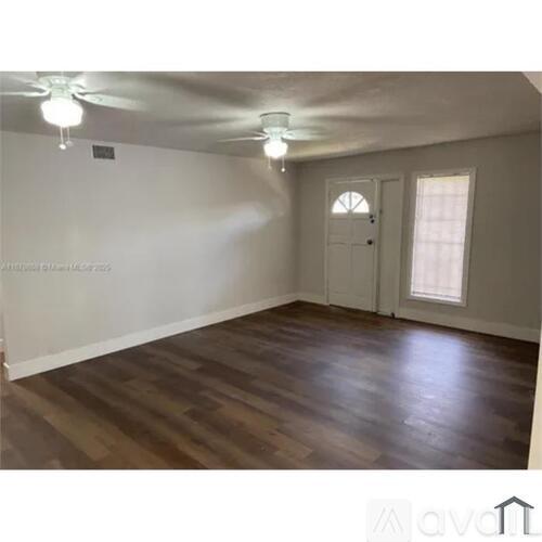 A room with wooden flooring and a ceiling fan.
