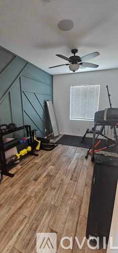 A room with a ceiling fan and exercise equipment.