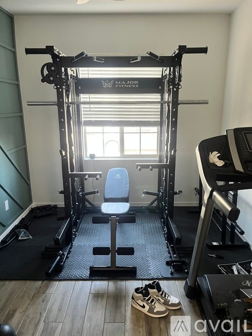 A home gym with a weight bench, a squat rack, and a pair of shoes on the floor.