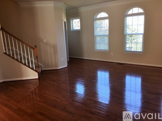 A room with wooden floors and two windows.