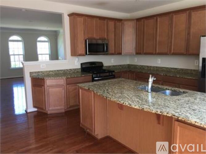 A kitchen with wooden cabinets and granite countertops.