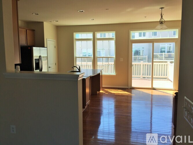 A kitchen with a refrigerator, microwave, and a dining table with chairs.