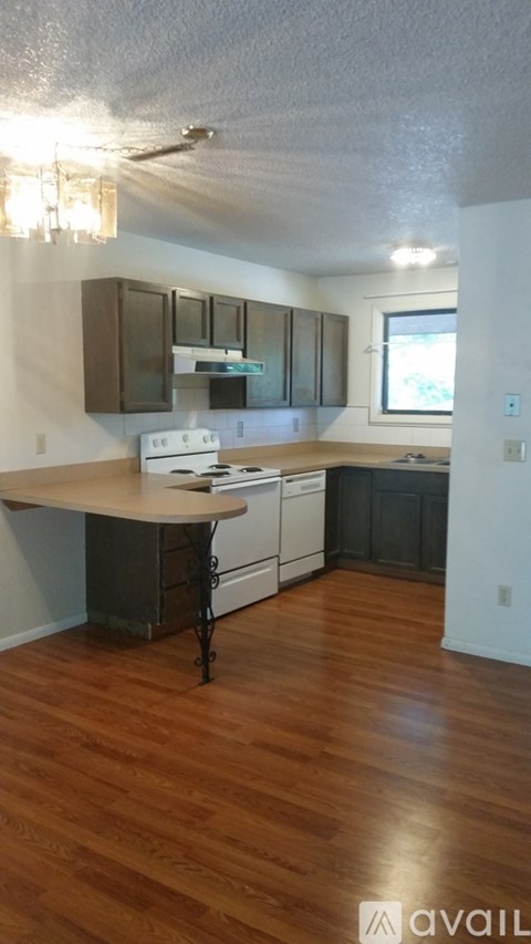 A kitchen with a white stove top oven and a wooden island.