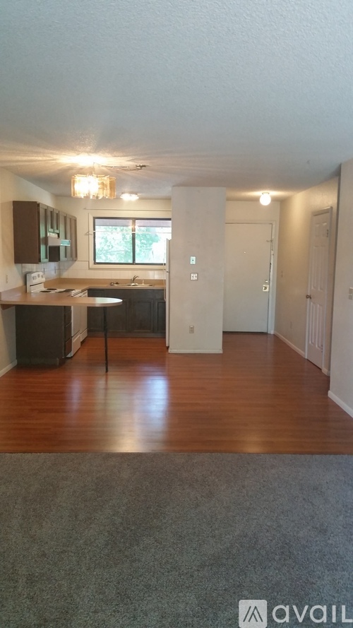 A kitchen with a table and chairs in front of a window.