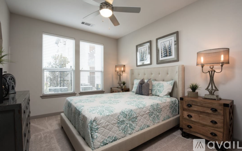 A bedroom with a bed, dresser, and ceiling fan.