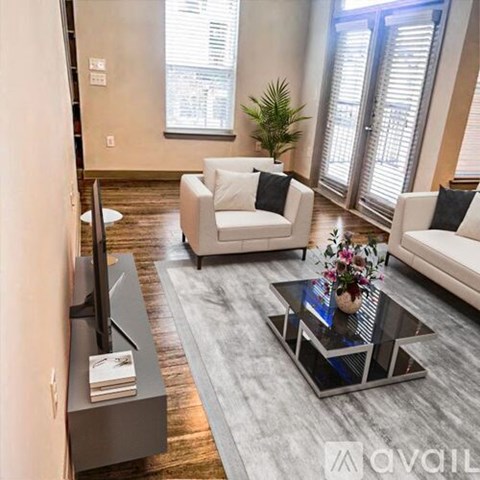 A modern living room with a glass coffee table and a flat screen TV.