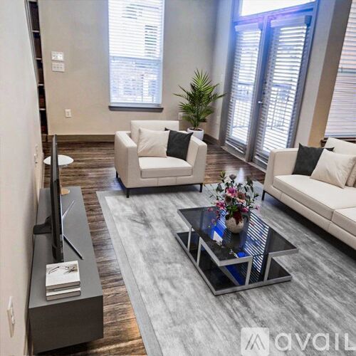 A modern living room with a grey coffee table and white sofas.