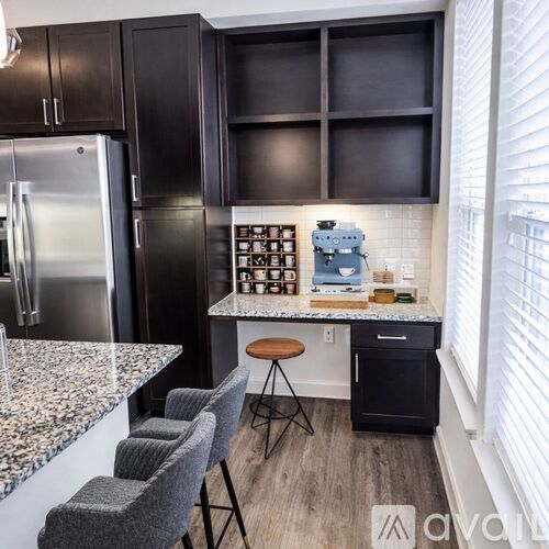 A kitchen with dark wood cabinets and a granite countertop.