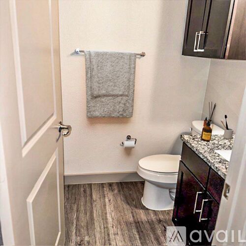 A bathroom with a toilet, a towel, and a cabinet.