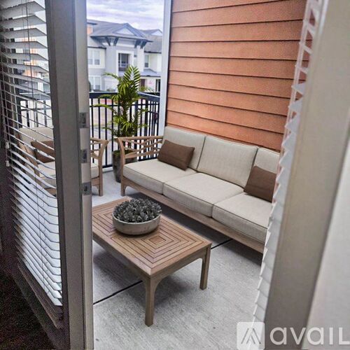 A patio with a couch, table, and a bowl of nuts.