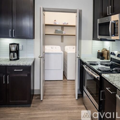 A kitchen with black cabinets and a white dishwasher.