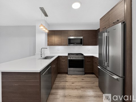 A modern kitchen with dark wood cabinets and stainless steel appliances.