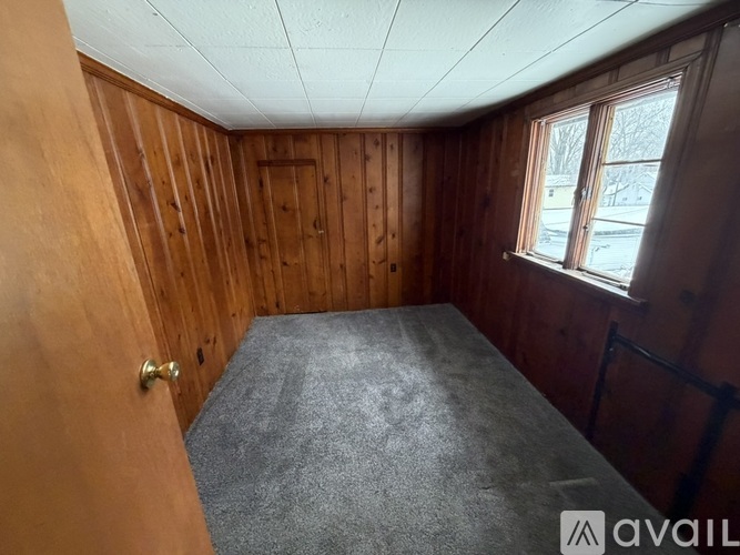 A room with wooden walls and a carpeted floor.