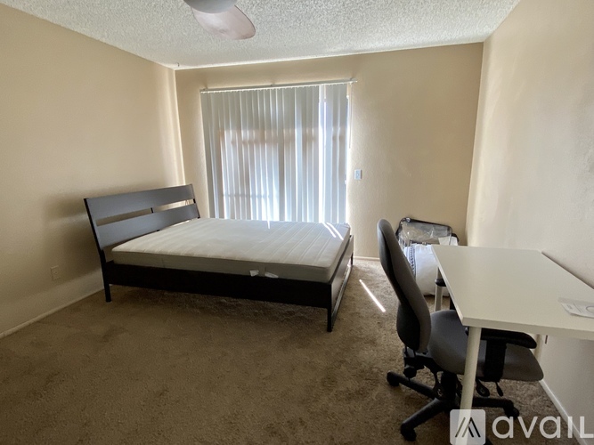 A bedroom with a bed, desk, and chair.