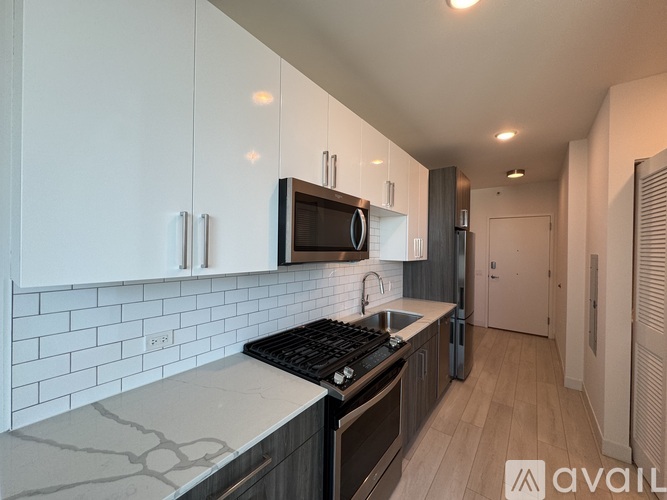 A modern kitchen with white cabinets and a black stove top.
