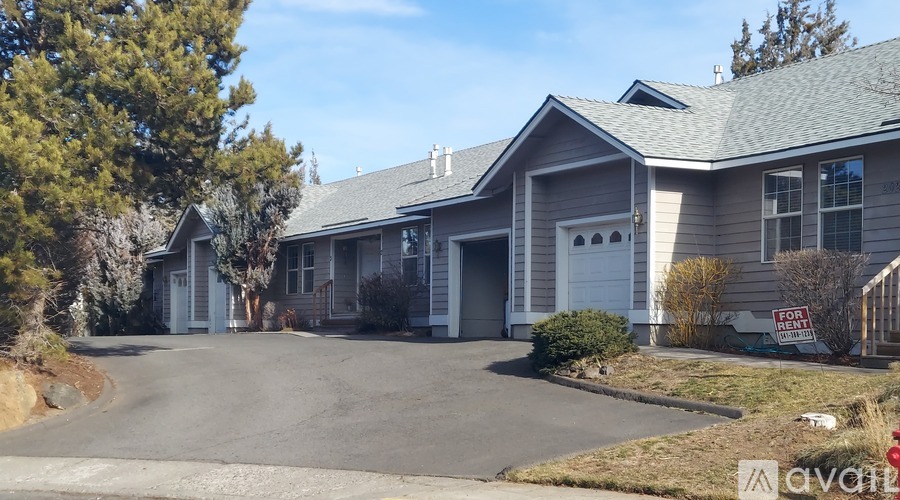 A house with a "For Sale" sign in front of it.