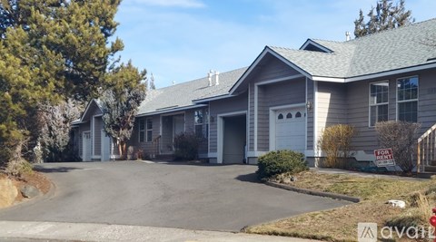 A house with a "For Sale" sign in front of it.
