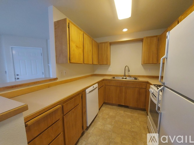 A kitchen with wooden cabinets and a white refrigerator.