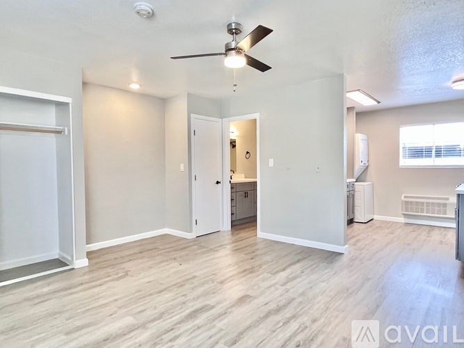 A spacious room with a ceiling fan and lighting fixtures.