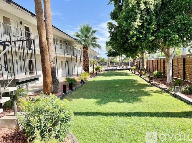 A sunny day at the apartment complex with well-maintained green lawns and trees.