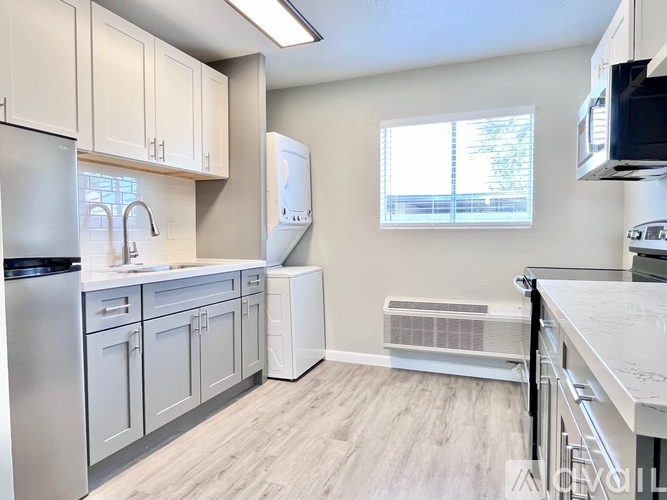 A kitchen with white cabinets and a white fridge.