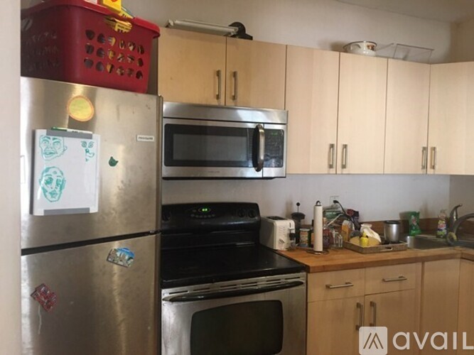 A kitchen with a refrigerator, microwave, oven, and sink.