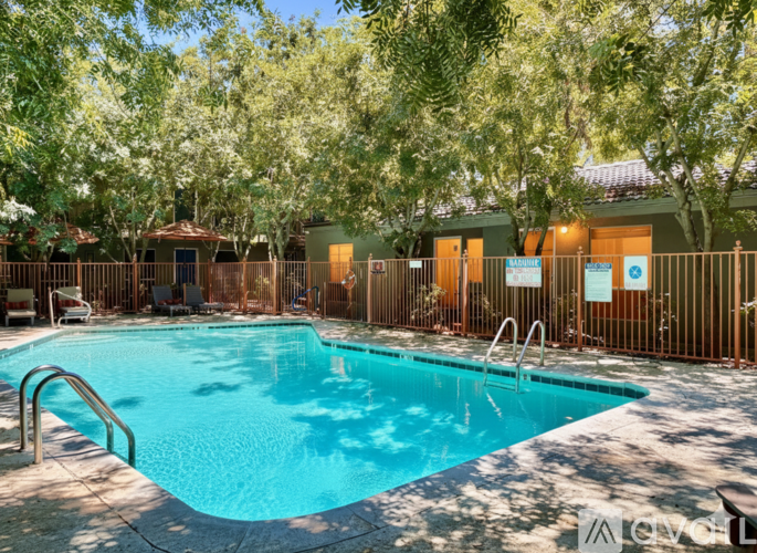 A pool surrounded by trees and a fence with a sign that says "Pool".