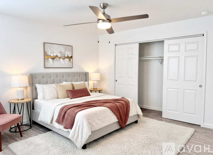 A bedroom with a large bed and a ceiling fan.