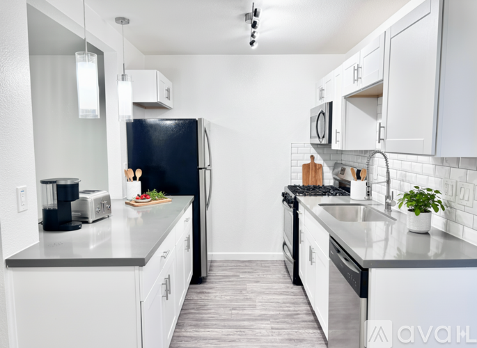 A kitchen with white cabinets and a black refrigerator.