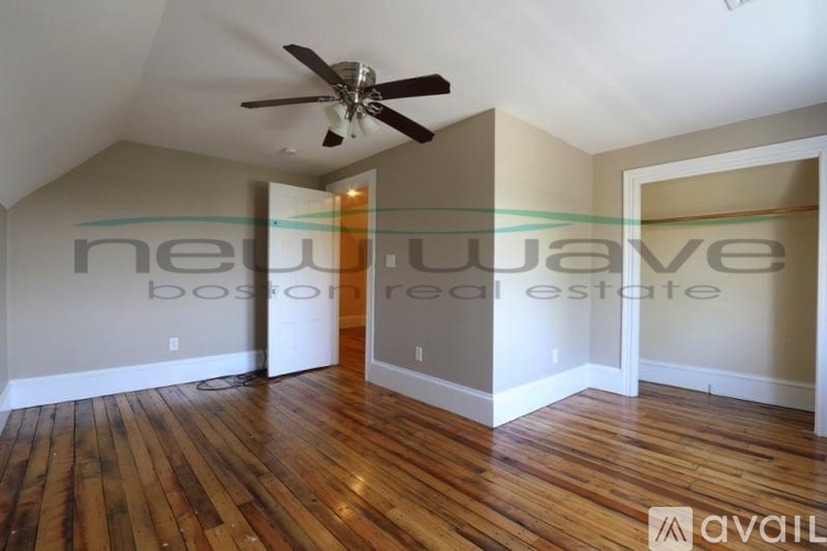 A room with wooden floors and a ceiling fan.
