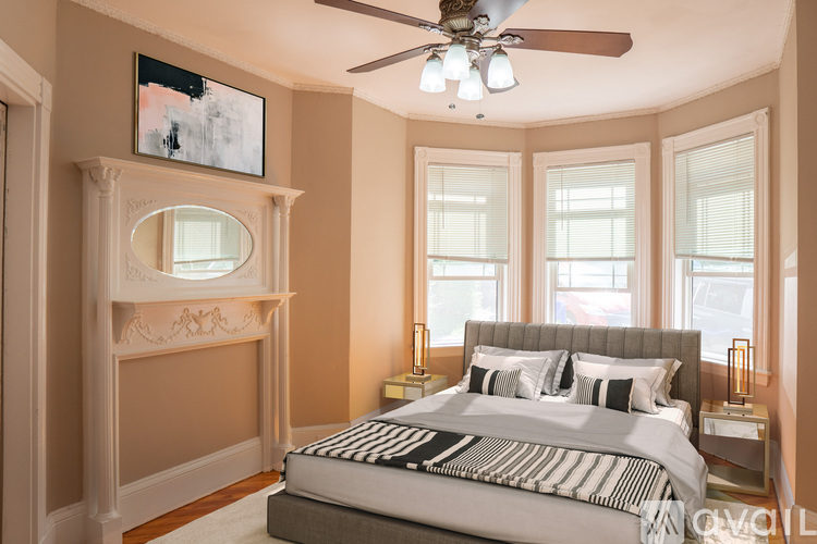 A bedroom with a large bed and a fireplace.