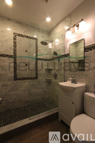 A bathroom with a glass shower enclosure and a white toilet.