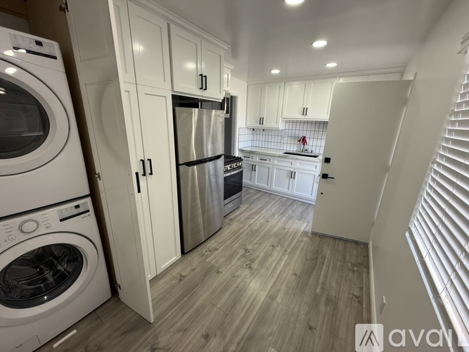 A modern kitchen with white appliances and cabinets.