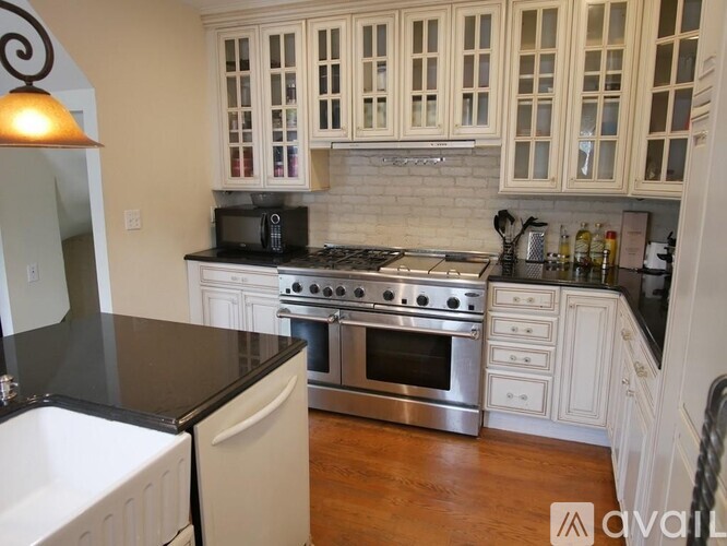A kitchen with white cabinets and a black countertop.