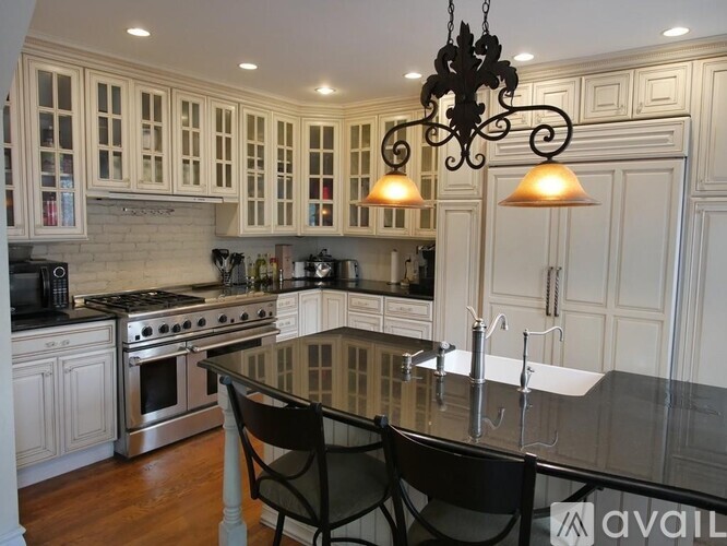 A kitchen with a black granite countertop and white cabinets.