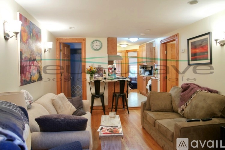 A living room with a couch, chair, and a dining table.