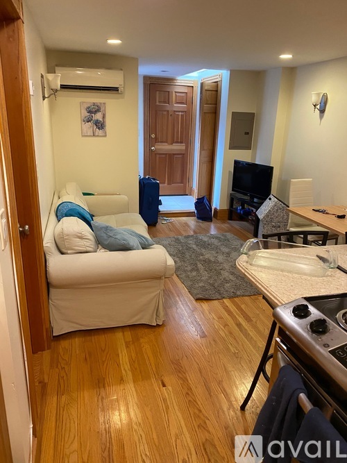 A living room with a white couch and a wooden floor.