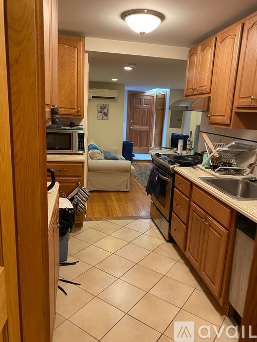 A kitchen with wooden cabinets and a white tile floor.