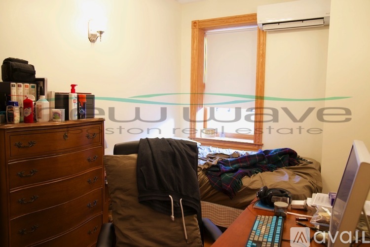 A room with a bed, a desk, and a computer.