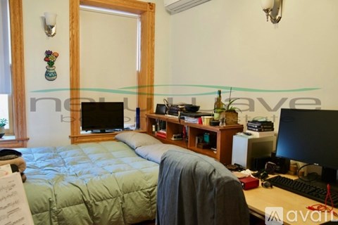 A bedroom with a bed, desk, and computer.