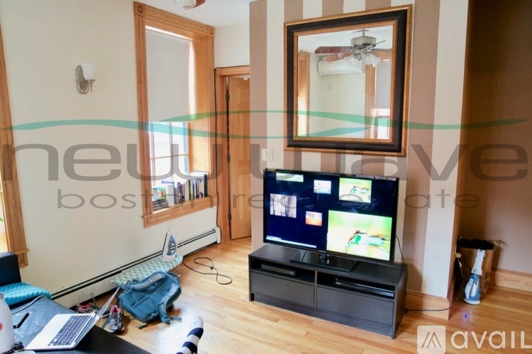 A living room with a television and a mirror on the wall.