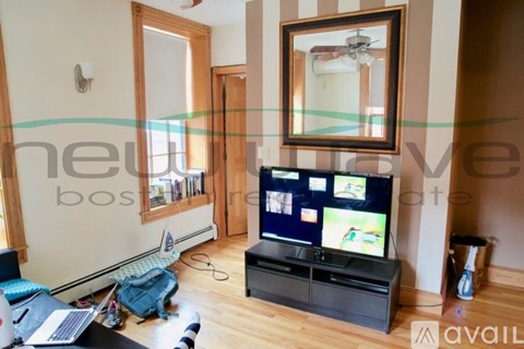 A living room with a television and a mirror on the wall.