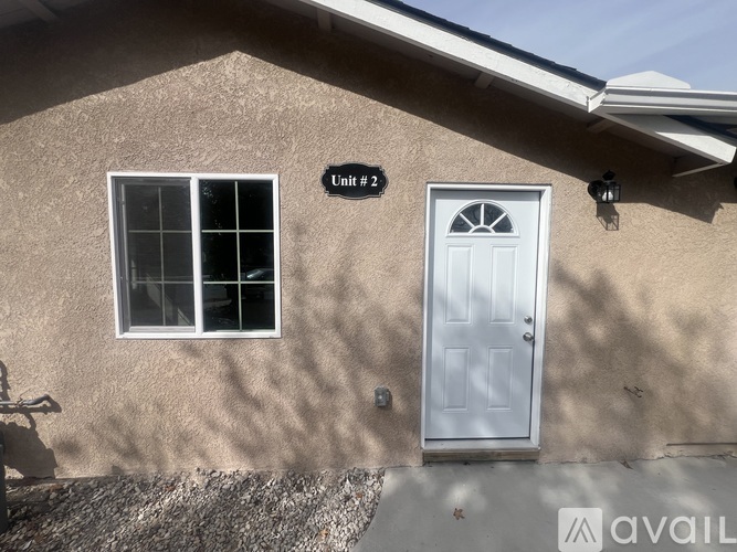 A house with a white door and window is labeled Unit #2.