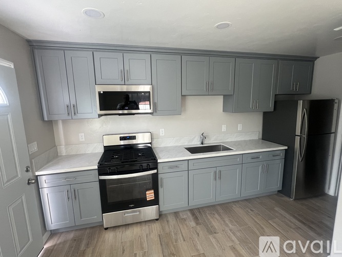 A kitchen with a stove top oven and a refrigerator.