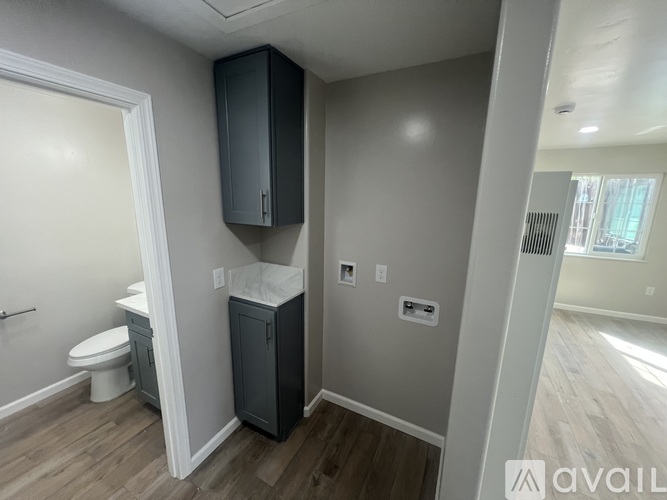A bathroom with a toilet, sink, and cabinet.
